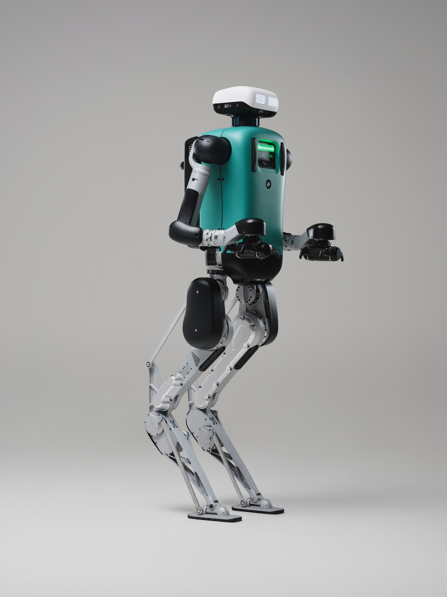 Agility Robotics Digit, the company's flagship humanoid robot, shown in a studio portrait with a teal torso, white sensor head, and reverse-knee legs